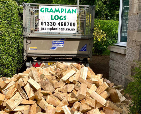 Fresh firewood delivery tipped beside a Grampian Logs trailer